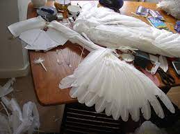 After drawing and cutting out the wings' shape, she spray paints the cardboard white and sticks feathers on it. How To Make A Pair Of Angel Wings 15 Steps With Pictures Instructables