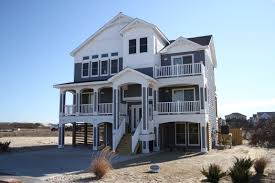 The owner's program called for specific elements to be included in the design, including wraparound porches on the front of the house, a completely rebuilt second floor, and an addition to the north side that included a new master suite wing and library. 624 Tide Arch Front Elevation Florez Design Studios