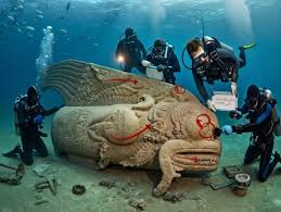 Off the rugged coast of Alexandria, divers have revealed a breathtaking  underwater site: what seems to be an ancient submerged temple crowned by a majestic  mermaid statue. Stone columns rise from the