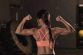 Certain back muscles extend to other areas, like the shoulders, upper arms, and thighs. Rear View Of Fit Woman Flexing Her Muscles Stock Photo Offset