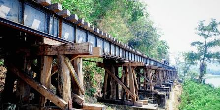 Crossing the wooden Krasae Cave Viaduct clinging to the cliff face above the Kwai Noi River., AI generated
