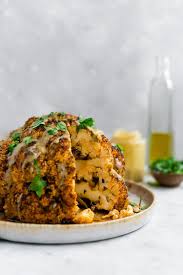 Whole Roasted Cauliflower With Tahini Sauce Truffles And Trends Whole Roasted Cauliflower Food Tahini Sauce