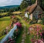 Thatched roof cottages with flowers surrounding them