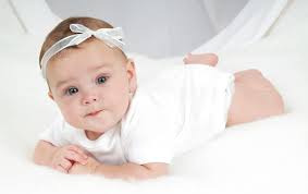Portrait of sweet smiling newborn daughter lying on cozy bed. Sweet Baby Hd Wallpapers Free Download