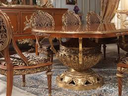 The table reflects highly decorative base with oversized scrolled feet, upholstered and tapestried chairs with the nail head trim accents, presenting a classic character and luxurious detailing dining room for you. Versailles Dining Room In Louis Xvi Vimercati Classic Furniture
