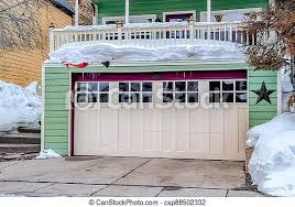 If the door is a heavy wooden one, you might need a 1 1/2 hp garage door opener. Two Car Garage With Glass Panes On White Door Under Snowed In Balcony Of Home The House Has Hreen Exterior Wall And Canstock