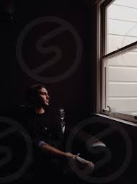 How to get window treatments like you see in magazines. Man Wearing Black Shirt Sitting Near Window By Luke Schoepf Photo Stock Snapwire