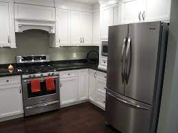The poliform kitchen is all white flat cabinets undercounter drawer refrigerators and glass stainless steel appliances. Kitchens Scotwend Homes Ltd White Cabinets Black Countertops Black Stainless Appliances New Kitchen Interior