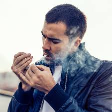 Un Homme Élégant A Saisi Une Cigarette Dans Sa Bouche. Gardez Un Briquet  Dans Sa Main Et Allez Fumer. Veste En Cuir Sexy Bad Boy. Mec Noir Avec  Coupe De Cheveux À