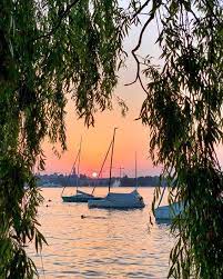 9 30pm on the shores of lake zurich switzerland still over 30c summerinzurich zurichsee zurich zurich boats water sunset redsky instagram zurich see