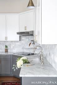 Two Toned Gray And White Cabinets Marble Subway Tile Carrara Countertops A Big Farmhouse Sink And Brass H Home Kitchens White Marble Kitchen Kitchen Design