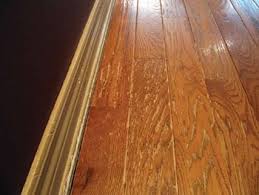 A Prefinished Solid Wood Floor And Baseboard Show Damage Caused By Repeated Use Of A Steam Mop Cleaner Wood Floors Floor Maintenance Solid Wood Flooring