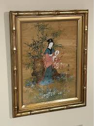 Asian watercolor painting. depicting a woman in traditional attire. Frame: It is encased in a gilded faux bamboo frame. Features;! a signature and a red stamp. Subject: Commonly titled "Oriental Princess" or "
