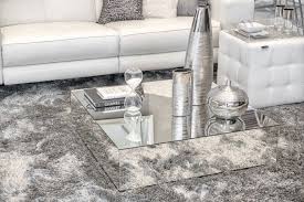 A glass coffee table with books, large jars. Piagia Coffee Table Coffee Table Decor Living Room Coffee Table Mirrored Coffee Tables