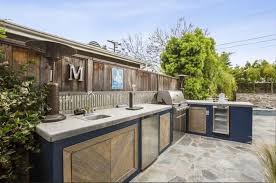 With the stacked stone counter and an outdoor sink, this outdoor kitchen is the complete package. Outdoor Kitchen Countertops Popular Designs Designing Idea