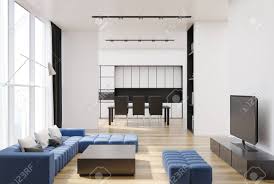 This blue living room chooses shades of brown to help support the heavy navy blue. White Living Room Interior With A Long Blue Sofa A Tv Set A Stock Photo Picture And Royalty Free Image Image 92876286