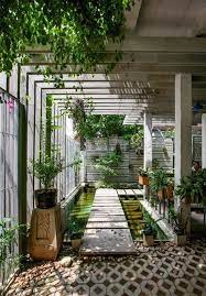 Position on a console table and couple with photo frames or house plants. Love The Jungle Feels Of This Bridged And Covered Outdoor Hallway Garden Landscape Design Landscape Design Backyard Landscaping