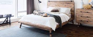 Scandinavian Bedroom Furniture Froy Com A scandinavian bedroom with a wooden bed and bench, some bulbs hanging down and pastel touches.