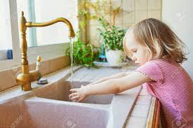 adorable toddler girl washing her hands