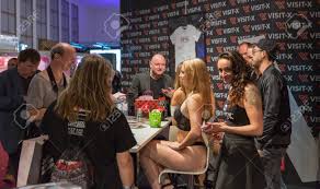 BERLIN, GERMANY - OCTOBER 17, 2019: Woman Actress Works At Visit-X Online  Porno Video Live Sex Cams Booth During 23th Venus Erotic And Lifestyle  Trade Fair In Messe Exhibition Hall. Stock Photo,