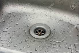sink with water drops. plug hole of a