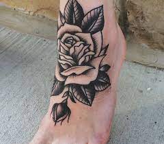 The most common meaning for a black rose tattoo is grief and death (via 500tattoos).since black is a color associated with death, people often get this tattoo in memory of someone who has passed away (via underground ink).in the west, black is the color associated with grief, however, in the east, the color associated with grief is white (via funeral guide). Traditional Style Black And Grey Rose Tattoo On Foot Traditional Rose Tattoos Black And Grey Rose Tattoo Foot Tattoos