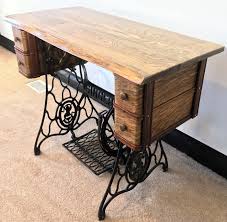 Old sewing wooden drums or skeins on an old wooden worktable with scissors. Singer Sewing Machine Table With Drawers