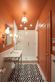 Orange primary bedroom featuring a shed ceiling and carpeted flooring, along with glass windows and a single bed set. 25 Orange Bathroom Decor Ideas That Inspire Shelterness