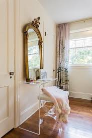 A Gold Mirror Leans Atop A Cb2 Peekaboo Clear Console Table Seating An Acrylic Vanity Bench Topped With A Whi Dining Room Console Table Home Living Space Decor