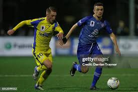 Michael Holden of the Strikers and Adrian Mancini of Northcote City... News  Photo