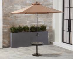 The patio umbrella side table features a large, open wicker basket for storing outdoor essentials. Darby Home Co Dominquez Cast Top Umbrella Aluminum Side Table Wayfair