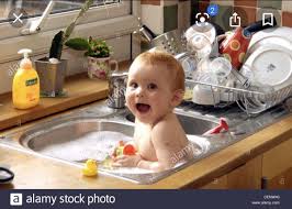 Child playing with foam and soap bubbles in sunny kitchen with rubber ducks and toys. Why Do Some People Bathe Their Babies In The Kitchen Sink Isn T It Unhygienic Quora
