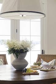 This is because they are not just used for dining but also are used to enhance aesthetic looks nevertheless, getting a quality kitchen set can an arduous task. White Hanging Drum Light Over Round Brown Dining Table Cottage Dining Room