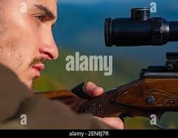 Close up snipers carbine at the outdoor hunting. Hunter with shotgun gun