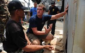 Navy Diver 2nd Class David Orme explains the procedures for cutting steel  objects underwater to a Panamanian diver
