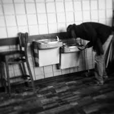 Young black boy drinking at a water fountain with a 'colored' sign above it, halifax, north carolina, united states of america. Double Water Fountains About