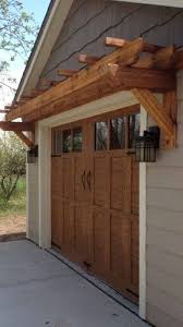 With A Wood Tone And Carriage House Design These Garage Doors Have A Stand Out Style With Windows Panel Design H House Exterior Garage Door Trim House Front