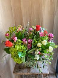 This gorgeous mix of lilies, daisy poms, alstroemeria, statice and aster is perfectly complemented by a clear vase boasting a purple organza ribbon. Secret Garden Vanda Floral Design