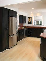Once your cabinets have been installed, wipe down all exteriors with a damp cloth to remove dust. Black Cabinets With Wine Rack Contrast With The Blonde Hardwood Floors And Rich Brown Granit Modern Kitchen Design Maple Hardwood Floors Black Kitchen Cabinets