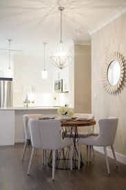 A Round Wood And Iron Lattice Dining Table Sits Surrounded By Modern Light Gray Linen Dining Chairs Lit Dining Room Small Condo Living Room Elegant Dining Room