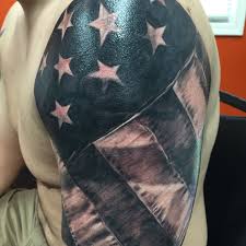 The tattoo depicts an american flag draped over a wooden cross that is in a field. Pin On Tattoos I Ve Done