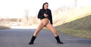 Девушка писает, стоя на дороге