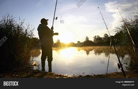 Man fishing big and small fish at river, lake, ice and sea with small boat for recreation. Silhouette Man Fishing Image Photo Free Trial Bigstock