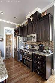 Black cabinets can be chic, modern, sleek, and warm, sometimes all at the same time. Cabinets Pantry Stainless Steel Wine Rack Rustic Kitchen Design Rustic Kitchen Black Kitchen Cabinets