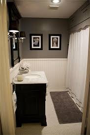 The brass mirror really stands out against the gray wallpaper while the two brown nickel and glass wall sconces tie it all together. Future Bathroom Updates Hex Tile Wainscoting Marble Vanity Gray Paint Dark Vanity Bathrooms Remodel Bathroom Update