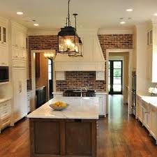 Since the kitchen cabinets are plain white with white soap stone counter top and white walls, the brick walls adds texture and pattern,breaking the monotony of the kitchen design and balances the brightness of the white surfaces with the dark reds of the bricks. I Love The Farmhouse Feel Of This Kitchen Clean And Bright White Cream Cabinets And Countertops With The Warm Brick Home Brick Kitchen White Shaker Kitchen
