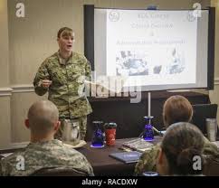 Army Reserve Brig. Gen. Nikki Griffin-Olive (left center), deputy commander  of sustainment, 335th Signal Command (Theater) unfurls the brigadier  general officer flag with her husband, Col. Jeffrey A. Olive (right),  commander of