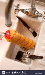 washing paint brushes and a roller in a