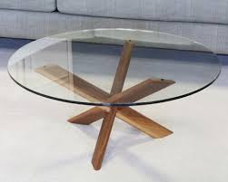 The wooden base consists of turned legs and side stretchers, giving a. Glass Top Table With Modern Wooden Cross Base