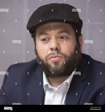 Stand-up comedian and actor Daniel Lawrence Whitney, better known by the  stage name Larry the Cable Guy (C), talks to Seattle Mariners' pitcher Roy  Corcoran (L) and Performance Coach Steve Hecht (R)